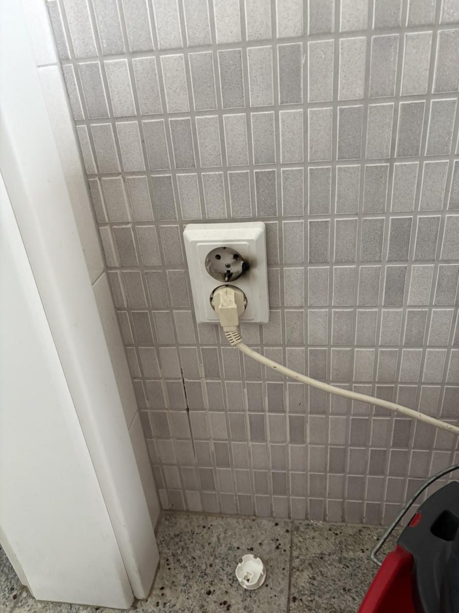 Prise électrique vétuste en saillie dans une salle de bain à remplacer aux normes au Luxembourg